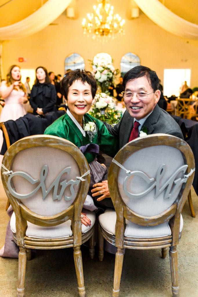 Father and mother sitting in Mrs. and Mr. chairs